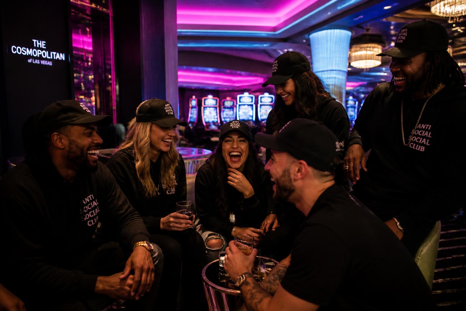 Friends in Total Slots apparel laughing together in a casino resort lounge